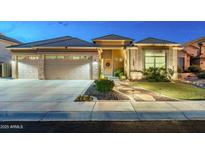 Inviting home exterior showcases a three-car garage, stone accents, and desert landscaping at 6326 W Misty Willow Ln, Glendale, AZ 85310