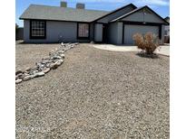 Charming single-story home featuring a low maintenance rock front yard and attached two car garage at 8703 W Golden Ln, Peoria, AZ 85345