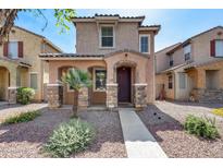 Charming two-story home featuring a covered entryway, a landscaped yard with decorative rock at 9 N 87Th N Ln, Tolleson, AZ 85353