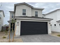Charming two-story home featuring a gray stucco exterior, a black garage door, and a paved driveway at 1530 N Pueblo Dr, Apache Junction, AZ 85120