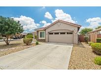Charming home featuring a two-car garage, a driveway, and desert landscaping, showcasing curb appeal at 19585 W Washington St, Buckeye, AZ 85326