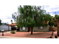 Charming single-story home featuring low maintenance landscaping, mature tree, and a cozy front porch at 3216 E Campo Bello Dr, Phoenix, AZ 85032
