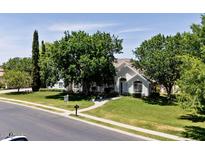 Charming single-story home with lush green lawn, mature trees, and inviting walkway at 3750 E Palm St, Mesa, AZ 85215