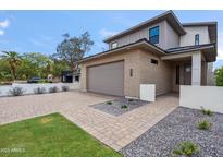 Modern two-story home featuring a brick facade, a two-car garage, and beautifully landscaped front yard at 5537 E Earll Dr, Phoenix, AZ 85018