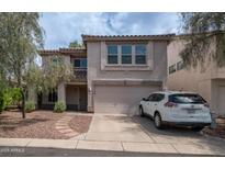 Two-story home with a two car garage, desert landscaping, and a white SUV parked on the driveway at 726 E Rose Marie Ln, Phoenix, AZ 85022