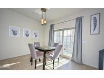 Dining room with a modern table and chairs under elegant lighting by a glass paneled door at 1851 W Vermont Ave, Phoenix, AZ 85015