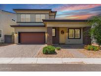 Charming two-story home featuring a red garage door, landscaped front yard, and covered porch at 1857 W 22Nd Ave, Apache Junction, AZ 85120