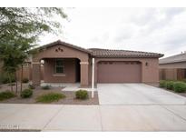 Charming single-story home featuring a tile roof, manicured landscaping, and a two-car garage at 21303 E Estrella Rd, Queen Creek, AZ 85142