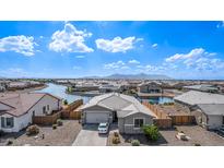 A well-kept single Gathering house with a neat yard and a lake, located in a well-maintained community at 22206 N Daniel Dr, Maricopa, AZ 85138