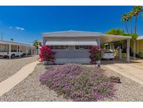 Charming home featuring a covered parking space with bright pink bougainvillea and purple flowers in the front yard at 2650 W Union Hills Dr # 16, Phoenix, AZ 85027