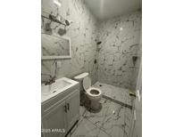 Well-lit bathroom featuring marble tile, vanity with white cabinets, and updated shower at 4049 N 81St Ave, Phoenix, AZ 85033