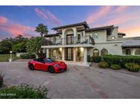 Stunning two-story home with a balcony and a beautiful red sports car in the driveway at 6611 N 64Th Pl, Paradise Valley, AZ 85253