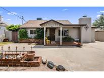 Charming single-story home featuring a quaint front porch and well-manicured landscaping at 901 E Hearn Rd, Phoenix, AZ 85022