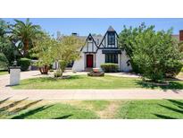 Charming Tudor-style home features a well-manicured lawn, mature trees, and a unique water fountain feature at 921 W Willetta St, Phoenix, AZ 85007