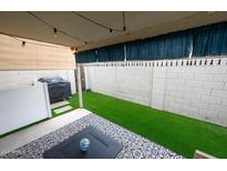 Inviting covered patio space with artificial turf, string lights, and patterned outdoor rug at 16021 N 30Th St # 127, Phoenix, AZ 85032