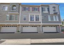 Three-story townhome featuring attached garages, stucco siding, and decorative shutters at 2402 E 5Th St # 1520, Tempe, AZ 85288