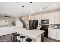 Modern kitchen boasts a spacious island with seating, stainless steel appliances, and stylish pendant lighting at 3900 E Baseline Rd # 137, Phoenix, AZ 85042