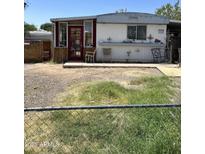 Charming single-story home with a red door and small porch, complemented by a spacious front yard at 4233 E Minton St, Phoenix, AZ 85042