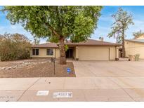Charming single-story home with a two-car garage and mature landscaping at 4510 W North Ln, Glendale, AZ 85302