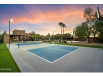 This backyard features a full sized tennis court, outdoor seating, and a beautiful sunset at 5630 E Peak View Rd, Cave Creek, AZ 85331