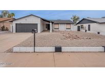 Charming single-Gathering home featuring a two-car garage and desert landscaping for low maintenance at 5817 S Siesta Ln, Tempe, AZ 85283