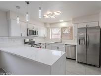 Stylish kitchen featuring stainless steel appliances, a breakfast bar, and elegant lighting fixtures at 5817 S Siesta Ln, Tempe, AZ 85283