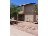 Two-story condo with a patio, desert landscaping, and gravel ground cover at 7120 E Wilshire Dr # 10, Scottsdale, AZ 85257