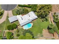 An aerial view showcases the home's swimming pool and large grassy backyard with mature trees and landscaping at 1298 E Buffalo St, Chandler, AZ 85225