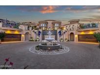 Circular driveway featuring a grand fountain leading to an opulent estate with dual garages at 15536 E Heavenly Vista Trl, Fountain Hills, AZ 85268