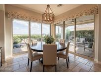 Bright dining area features a round table, chairs, and large windows offering beautiful outdoor views at 1617 E Copper Holw, Queen Creek, AZ 85140