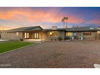 Spacious backyard featuring a covered patio, low-maintenance landscaping, and gravel ground covering at 1801 E Berridge Ln, Phoenix, AZ 85016