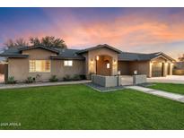 View of the home with a green lawn and an inviting front entrance with modern architectural details at 1801 E Berridge Ln, Phoenix, AZ 85016