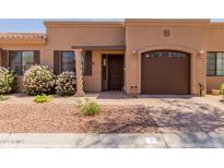 Charming single-story home featuring beautiful landscaping, a private garage, and a welcoming front entry at 4241 N Pebblecreek Pkwy # 7, Goodyear, AZ 85395