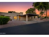 Charming single-story home with a covered carport and well-maintained landscaping at sunset at 446 S 77Th St, Mesa, AZ 85208