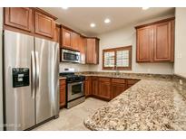 Well-lit kitchen with granite countertops, stainless steel appliances, and wood cabinets at 5350 E Deer Valley Dr # 1433, Phoenix, AZ 85054