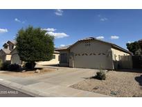 Charming single-story home featuring a well-manicured front yard, two car garage and desert landscaping at 8927 W Paradise Dr, Peoria, AZ 85345
