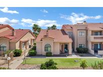 Well-maintained condo exterior with tile roof, desert landscaping, and mini-golf putting green at 16357 E Arrow Dr # 115, Fountain Hills, AZ 85268