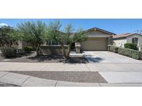 Charming single-story home featuring desert landscaping, a two-car garage, and a welcoming walkway at 16930 W Woodlands Ave, Goodyear, AZ 85338