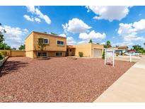 Tan home with a red rock yard, garage, and beautiful blue sky at 4802 W Hayward Ave, Glendale, AZ 85301