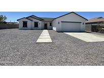 Charming one-story home with a gray gravel yard, concrete walkway and driveway, and a two car garage at 5499 E Red Bird Ln, San Tan Valley, AZ 85140