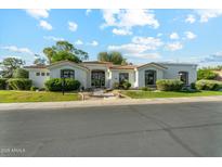 Beautiful single-story home with a red tile roof, manicured front yard, and black trimmed windows at 8196 E Sunnyside Dr, Scottsdale, AZ 85260