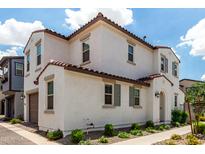 Charming two-story home with an arched entry, colorful landscaping, and brown trim on a bright day at 9901 E Tamery Ave, Mesa, AZ 85212