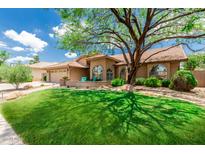 Inviting home with a well-manicured lawn and mature tree shading the front, creating a warm and welcoming curb appeal at 10105 E Larkspur Dr, Scottsdale, AZ 85260