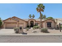 Inviting single-story home with desert landscaping, palm trees, and a charming tile roof at 12183 E Mercer Ln, Scottsdale, AZ 85259