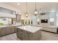 Open kitchen featuring a large island, gray cabinetry, stainless appliances, and stylish pendant lighting at 13361 N 99Th Pl, Scottsdale, AZ 85260