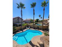 Inviting backyard oasis with a private pool, complemented by tall palm trees and desert landscaping at 16805 S 29Th Pl, Phoenix, AZ 85048