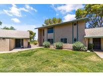 Inviting townhouse with green lawn, shrubs, and sidewalk under a partly cloudy sky at 18206 N 45Th Ave, Glendale, AZ 85308