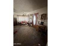 Cozy living room featuring vintage furniture and natural light from the large front window at 2102 W Hazelwood St, Phoenix, AZ 85015