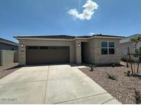 Charming single-story home with stone accents, a well-manicured yard, and a two-car garage at 25165 N 183Rd Dr, Wittmann, AZ 85361