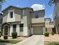 Two-story home featuring a stucco exterior, low maintenance landscaping, and an attached one-car garage at 6614 W Polk St, Phoenix, AZ 85043